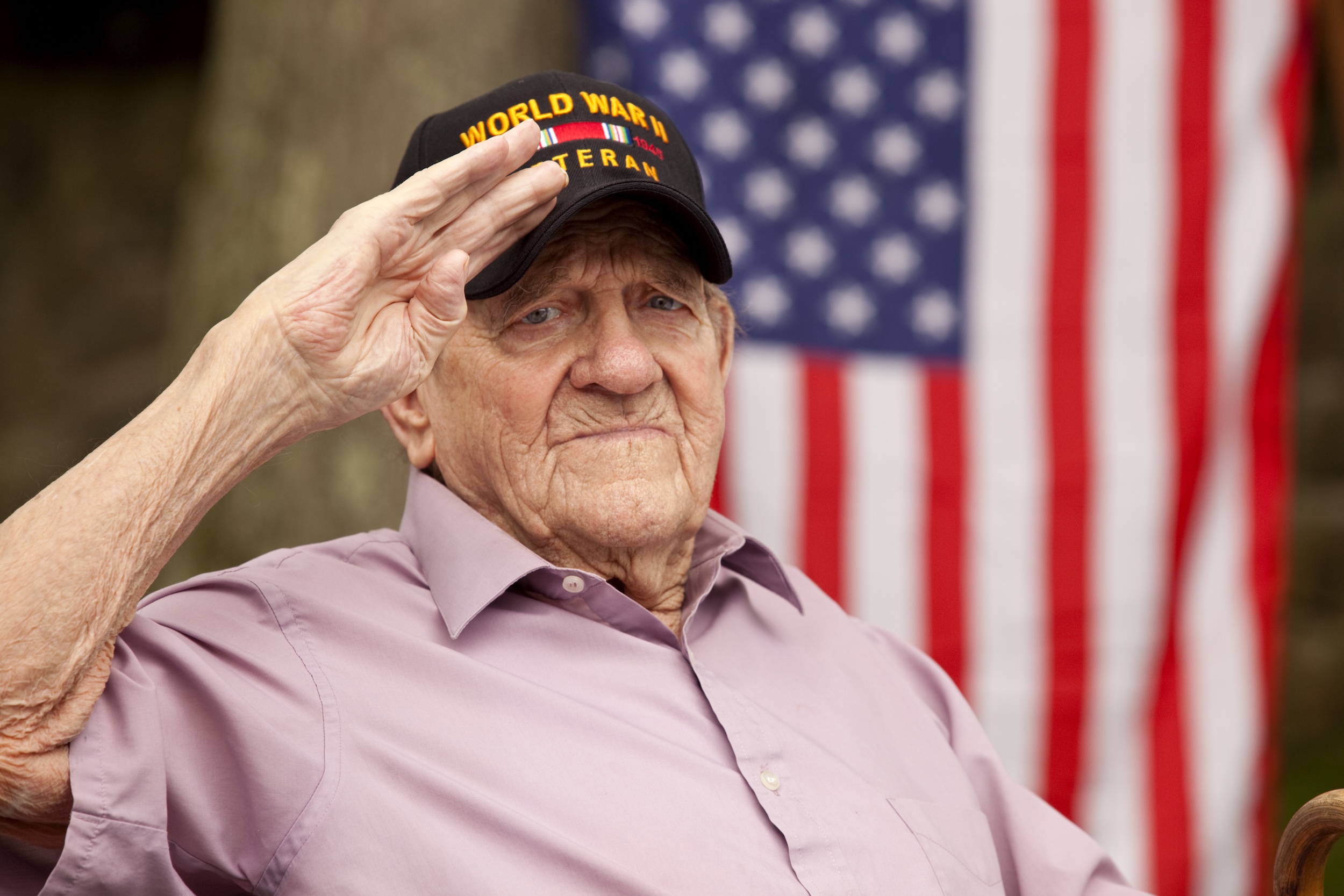 A proud veteran salutes against a backdrop of the American flag, embodying community and respect.