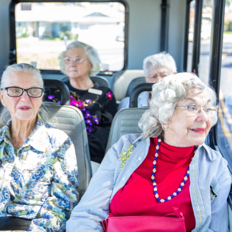 A joyful group of seniors enjoys a bus ride, sharing smiles and camaraderie in a vibrant community.