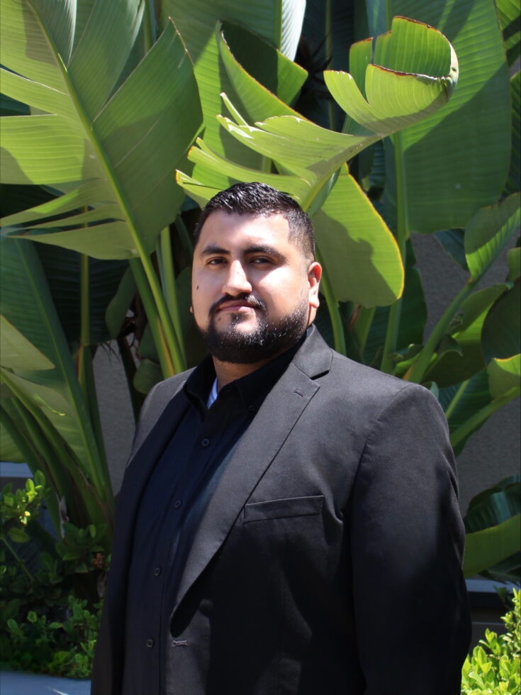 A welcoming atmosphere with lush greenery, showcasing a confident individual in professional attire.