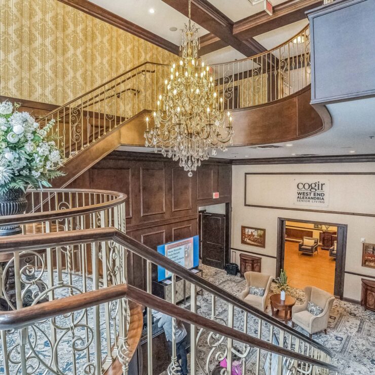 Elegant lobby with a grand staircase and floral arrangements, inviting a warm community atmosphere.