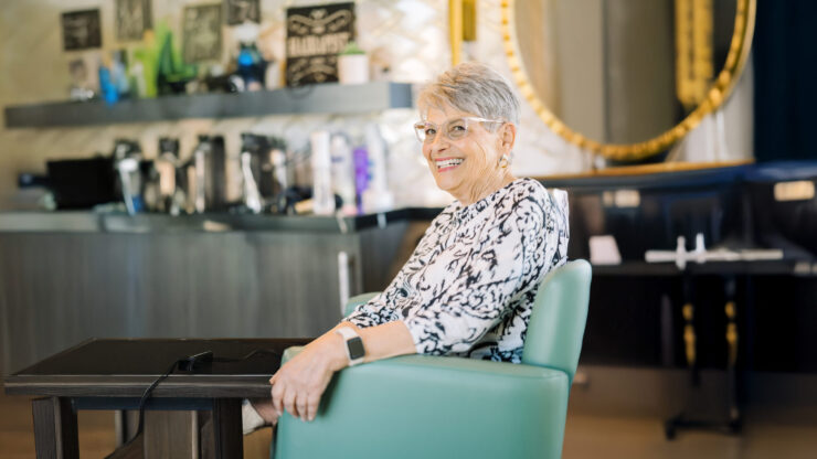 A joyful resident enjoys her time in a welcoming, vibrant common area, fostering community and connection.