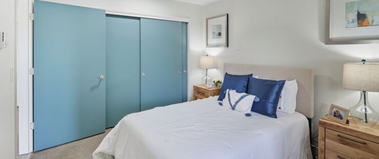 A serene bedroom featuring soft colors and inviting decor, perfect for comfort and community living.