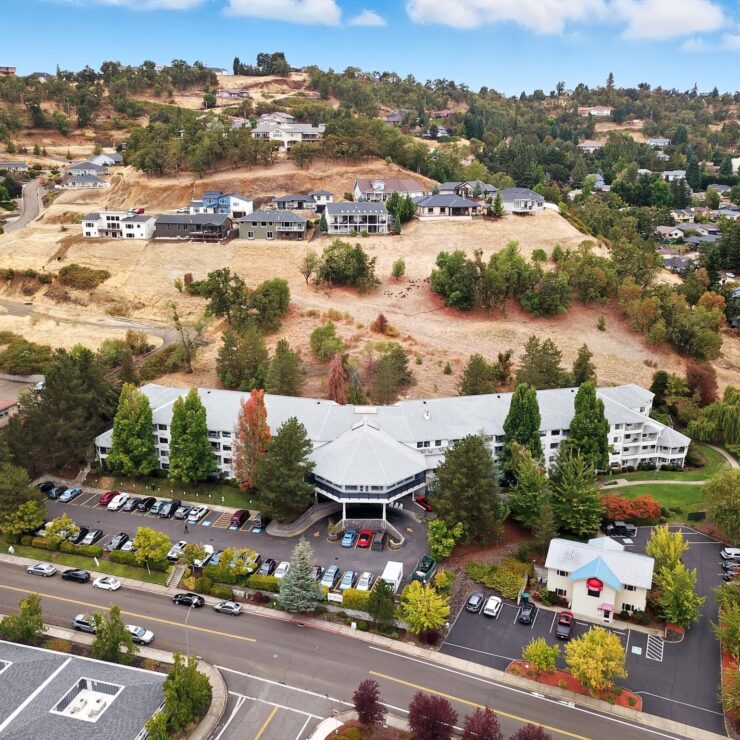 Retirement community surrounded by trees and hills, offering a peaceful and welcoming environment.