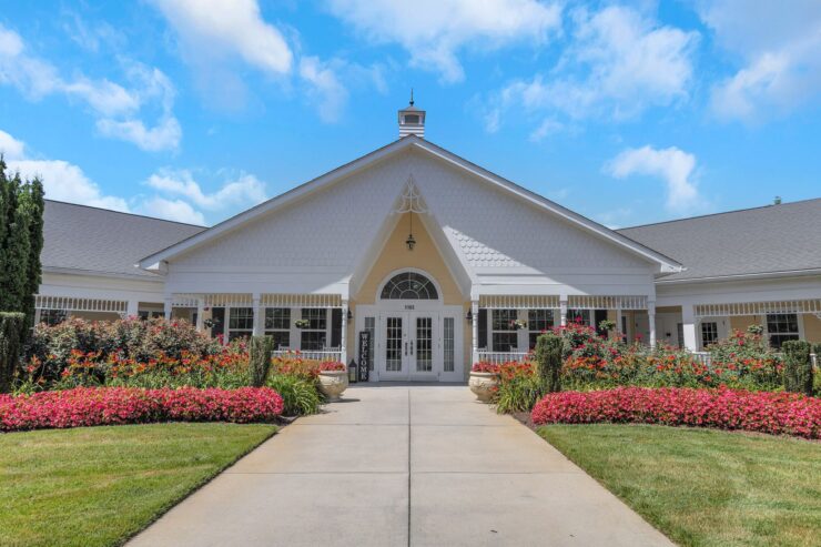 Well-maintained entrance to a welcoming retirement home surrounded by colorful flowers and greenery.