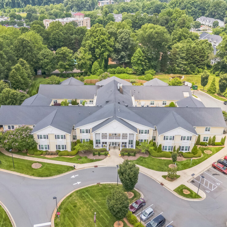 Well-maintained retirement community surrounded by lush greenery and ample parking spaces.