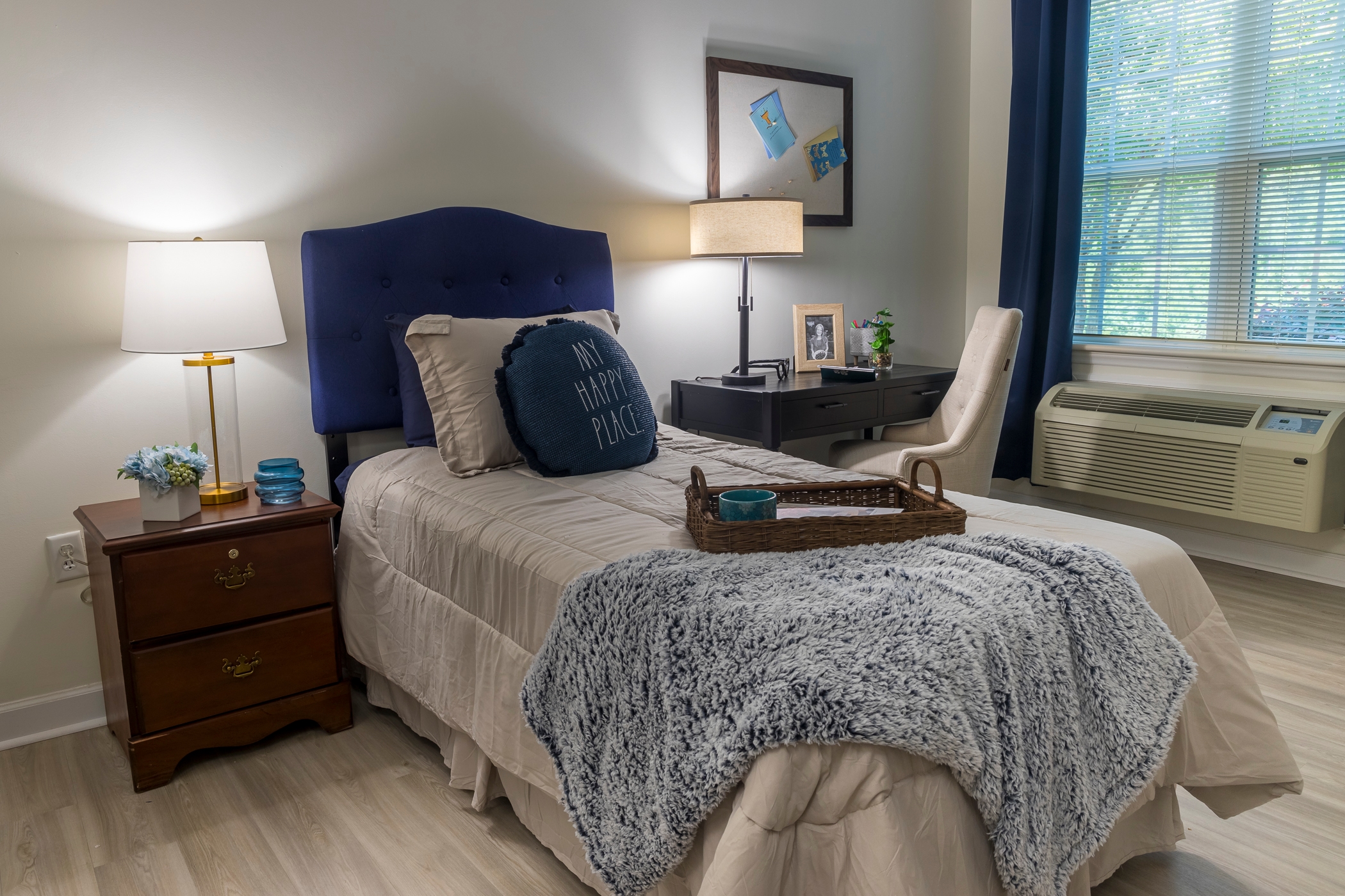 Bright, inviting bedroom with soft lighting, comfortable bed, and personal touches for a welcoming stay.