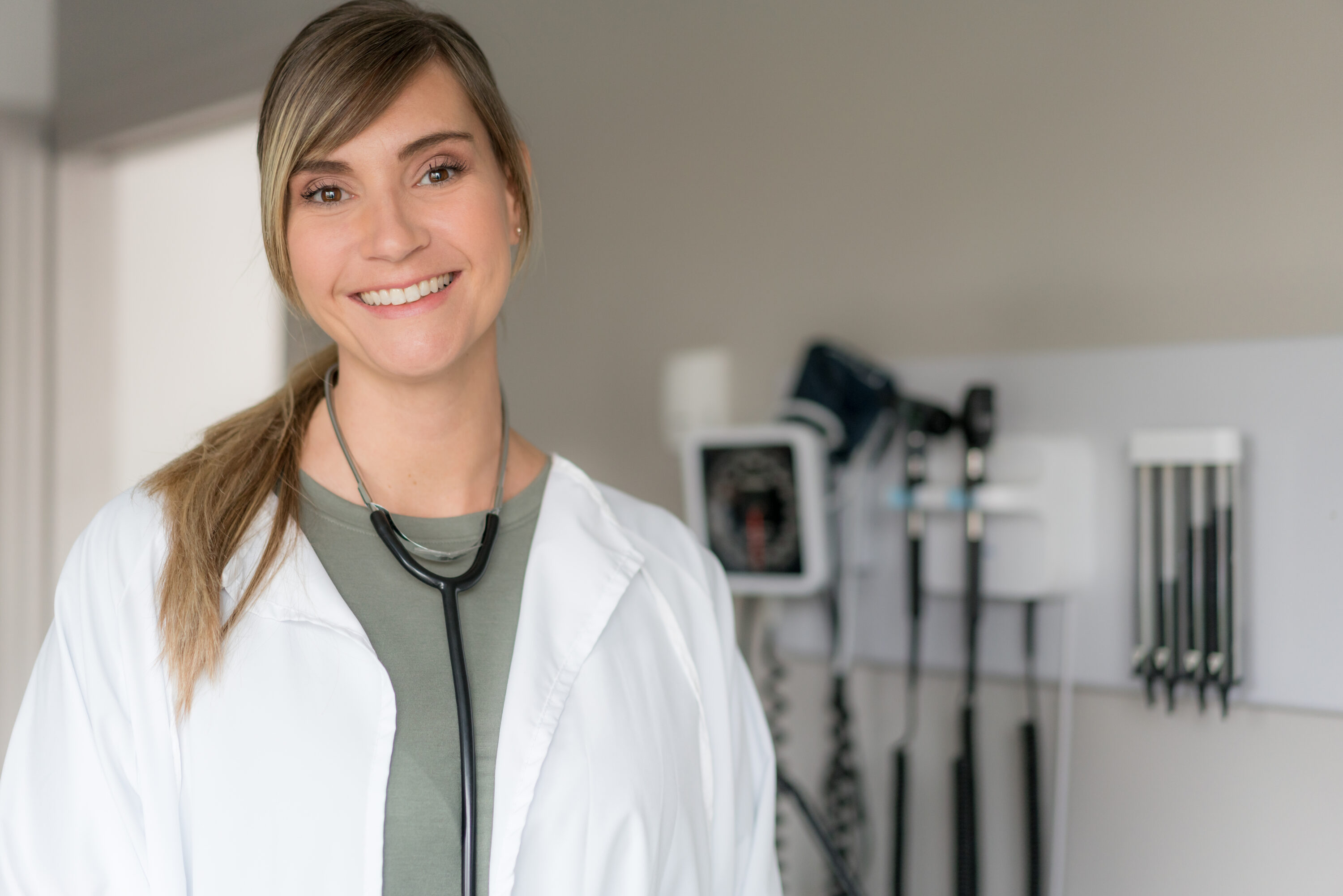 Friendly healthcare professional smiling in a well-equipped clinical space promoting wellness.