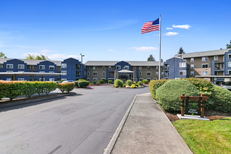 Well-maintained senior living community with landscaped grounds and clear visitor parking signs.