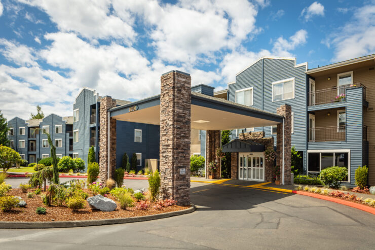Welcoming entrance to a vibrant retirement community with well-maintained landscaping and seating.