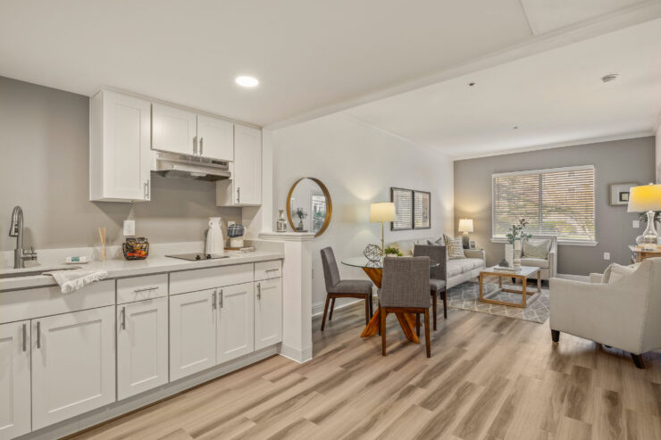 Open living and kitchen area with natural light, comfortable seating, and inviting dining space.