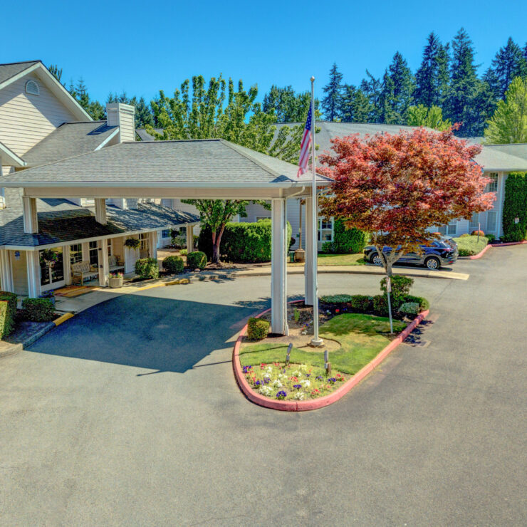 Well-maintained retirement community entrance with garden, seating, and welcoming atmosphere.