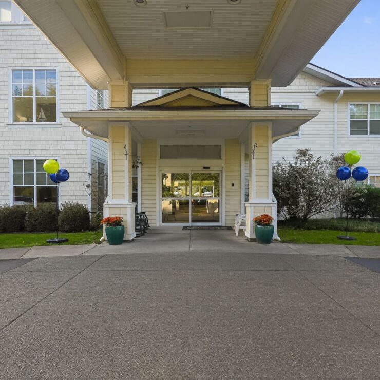 Welcoming entrance with cheerful balloons and vibrant landscaping, inviting community and comfort.