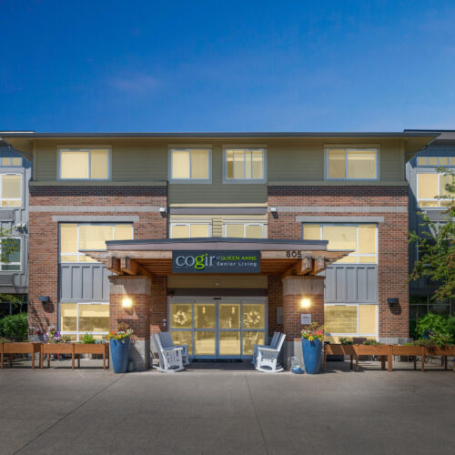 A welcoming entrance features vibrant greenery and inviting seating, perfect for community gatherings.