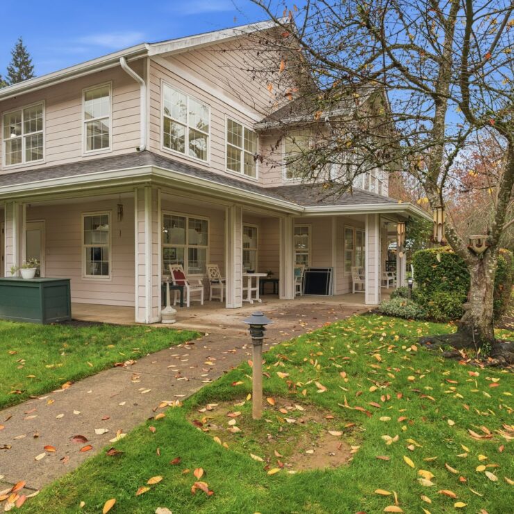 A welcoming exterior with vibrant greenery, inviting porches, and a serene atmosphere for community living.