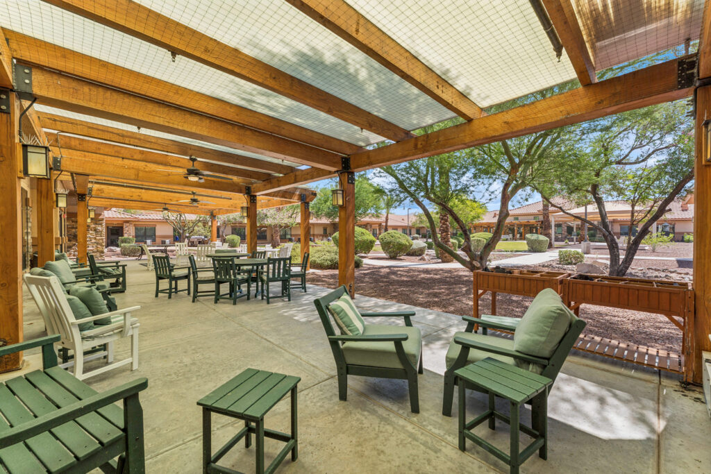 Inviting outdoor seating encourages relaxation and connection in a vibrant, sunlit community space.