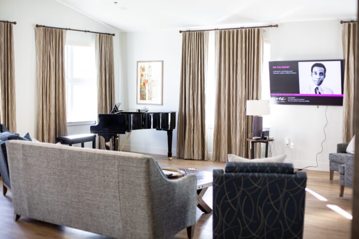 A welcoming lounge with elegant furnishings, a grand piano, and warm natural light, perfect for gatherings.