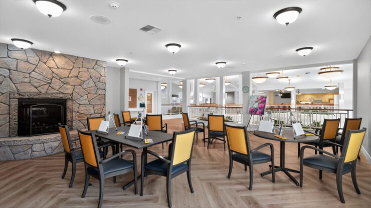 A welcoming communal space featuring comfortable seating, warm lighting, and a cozy fireplace.