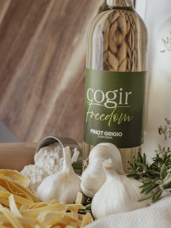 A warm kitchen scene featuring fresh ingredients, inviting aromas, and a bottle of wine, perfect for gatherings.