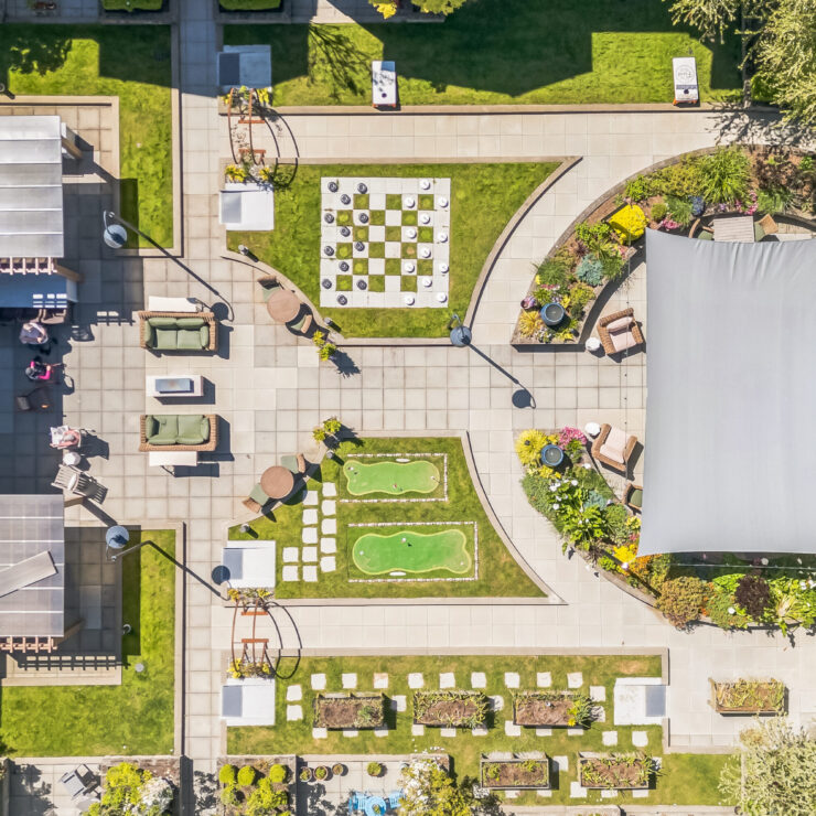 A vibrant outdoor space invites connection with seating, gardens, and activities for all.