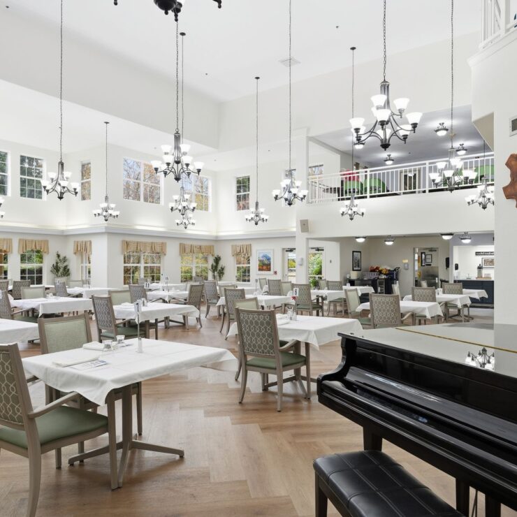 Bright and inviting dining area, featuring elegant decor and a piano, fostering community and comfort.