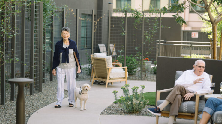 Residents enjoy a vibrant outdoor space, sharing smiles and companionship alongside their pets.