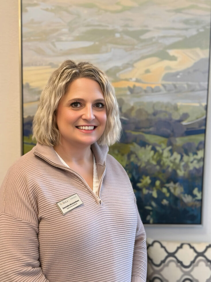 A warm smile welcomes visitors in a serene setting, highlighting community and care.