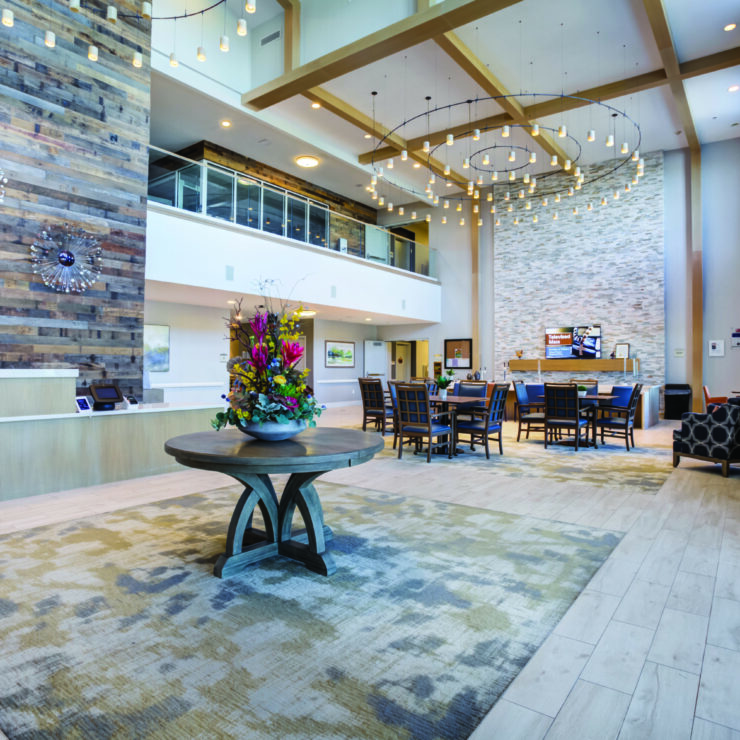 A welcoming lobby featuring elegant decor, vibrant flowers, and comfortable seating, promoting community and warmth.