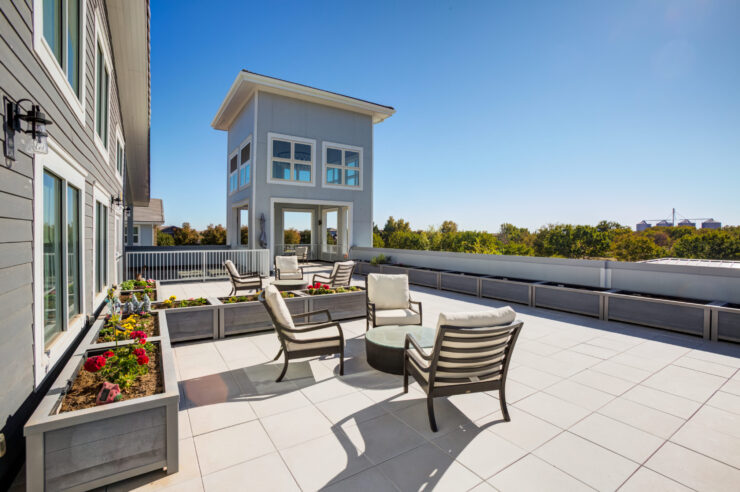 A welcoming rooftop space with comfortable seating and vibrant flower beds, perfect for community gatherings.