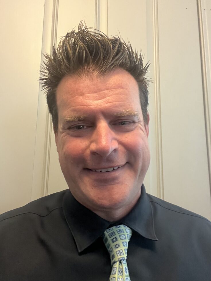 A warm smile and welcoming demeanor reflect a supportive community atmosphere.