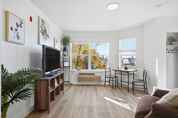 Bright and inviting space, featuring a cozy seating area and a lovely view of autumn trees.