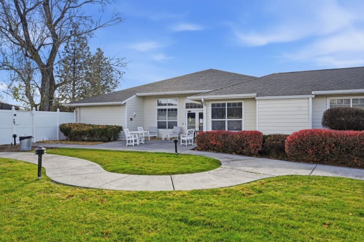 Welcoming pathways lead to a charming residence, surrounded by vibrant greenery and inviting seating.