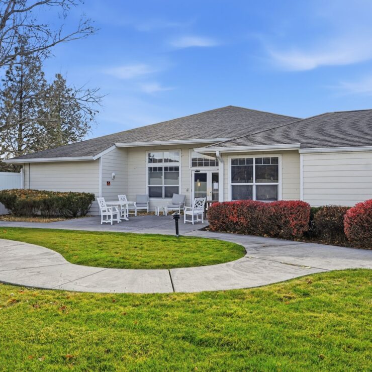 A welcoming entrance with lush greenery and seating invites community and relaxation.