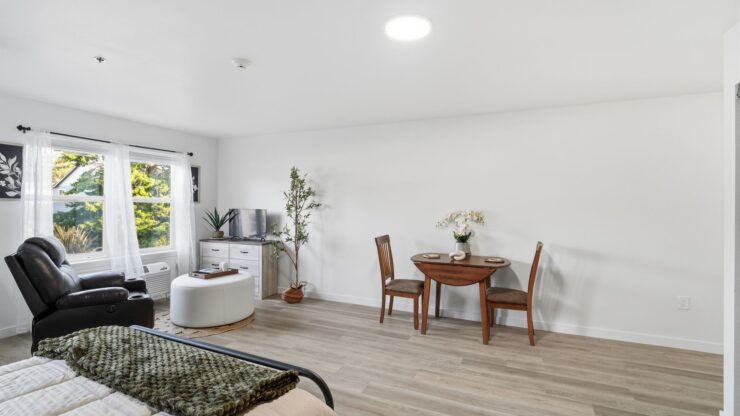 Bright and inviting, this space features a comfortable seating area and a dining table, perfect for community gatherings.