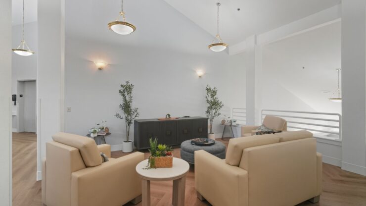 A bright, inviting lounge features comfortable seating and greenery, perfect for community gatherings.