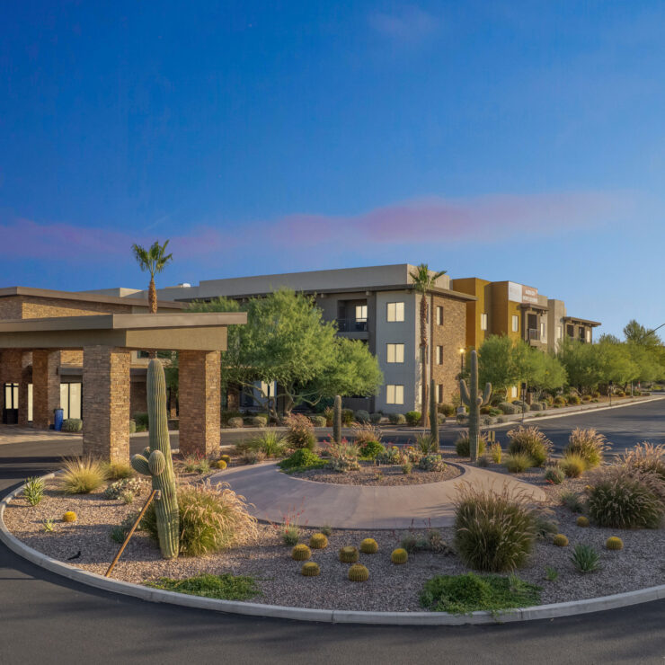 A welcoming entrance surrounded by lush landscaping and vibrant plants, inviting community and comfort.