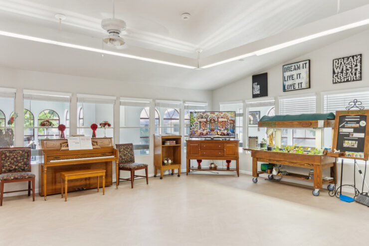 A welcoming activity space featuring a piano, inviting seating, and vibrant decor, perfect for community engagement.