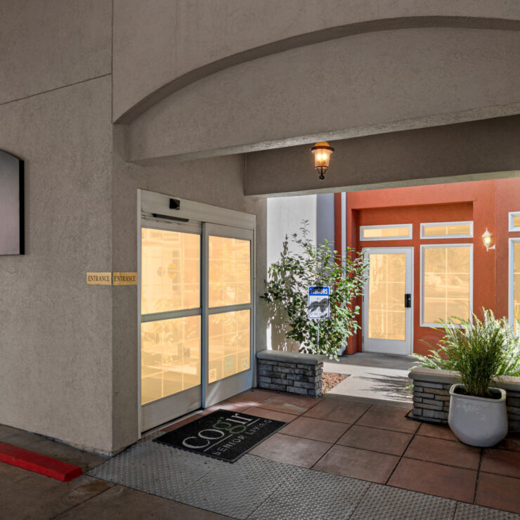 A welcoming entrance with warm lighting and inviting greenery, fostering community and comfort.