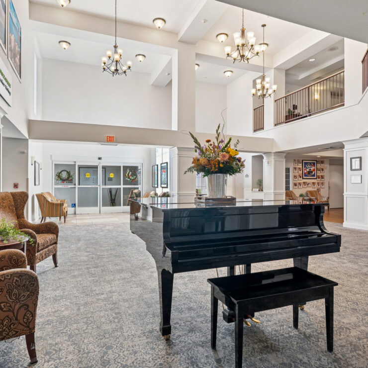 A welcoming lobby features elegant decor, inviting seating, and a grand piano, fostering community warmth.