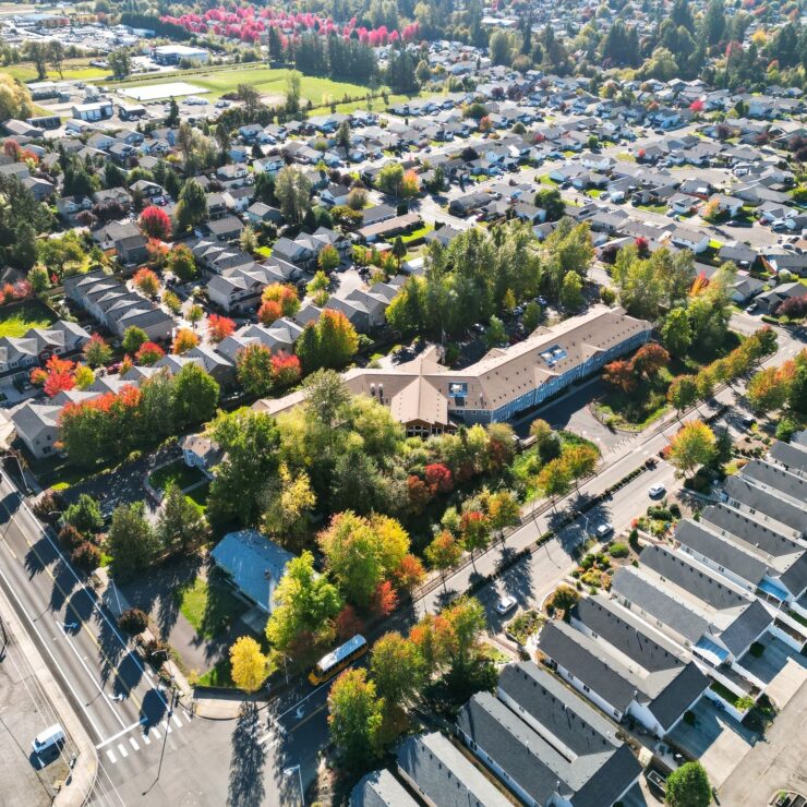 A vibrant community surrounded by lush greenery and colorful autumn trees, fostering warmth and connection.