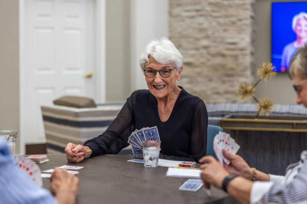 Engaging residents share laughter and camaraderie over a card game, fostering community spirit.