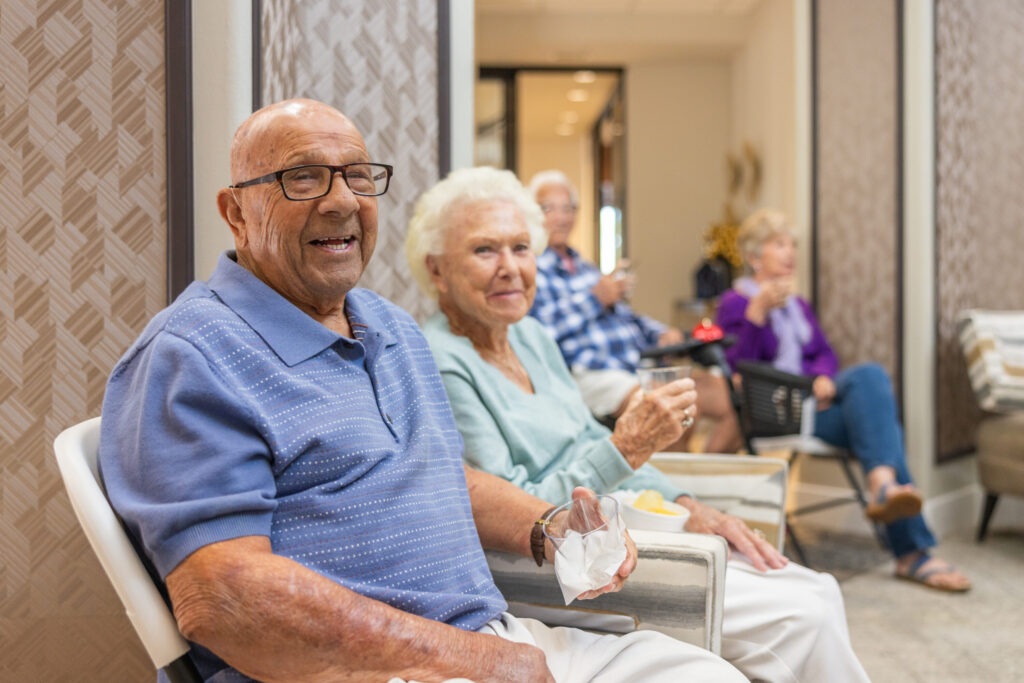 Lively residents enjoy friendly conversation in a welcoming, light-filled common area.