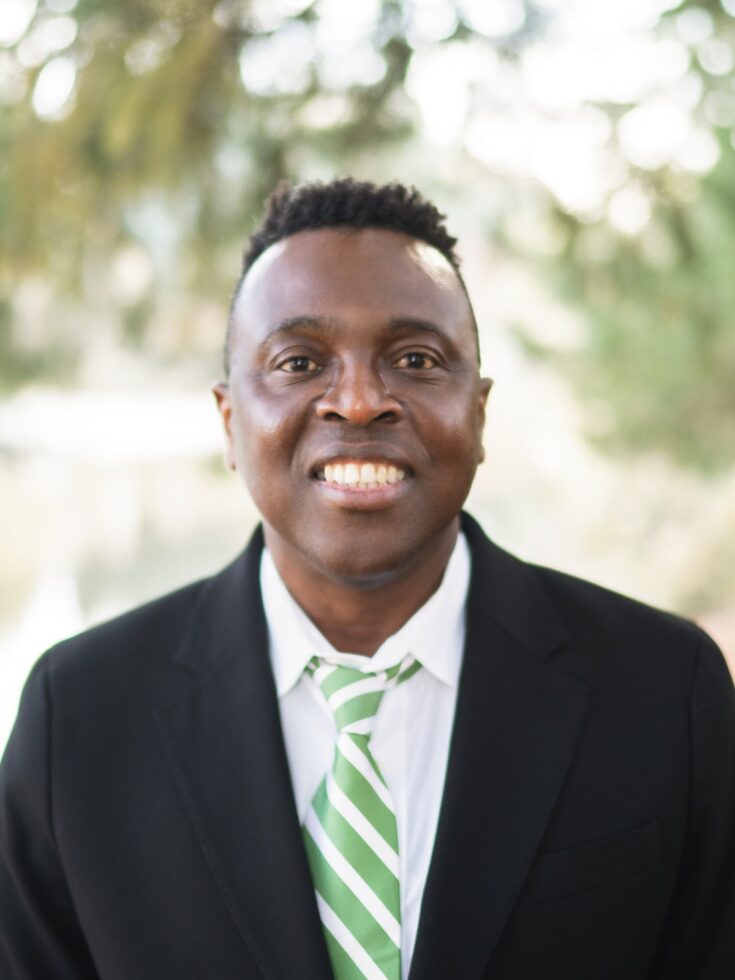 A warm smile radiates joy and connection, set against a serene, natural backdrop.