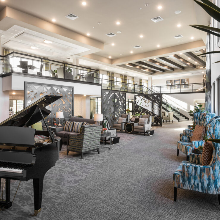 A welcoming lounge features elegant seating, a grand piano, and bright, airy spaces for community gatherings.