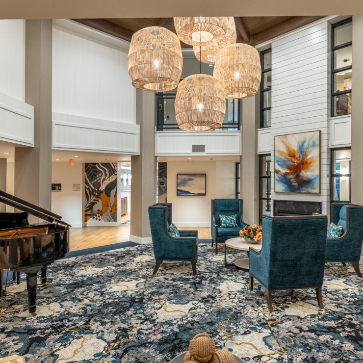 An inviting communal space featuring elegant furnishings, a grand piano, and warm lighting, perfect for gatherings.