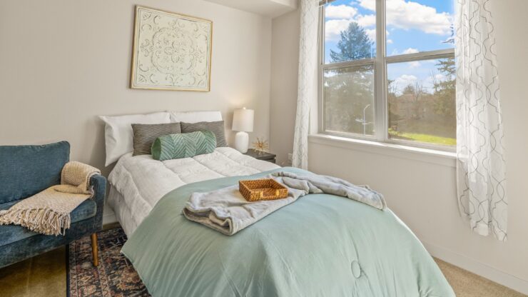 A bright, inviting bedroom featuring a cozy bed and a comfortable chair, perfect for relaxation.