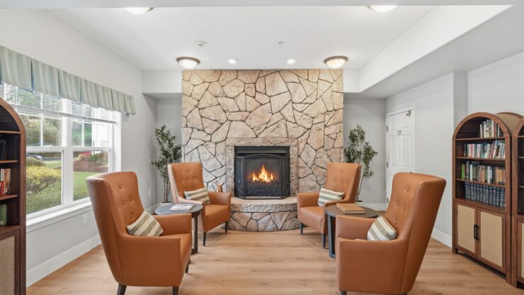 A welcoming lounge with plush seating around a warm fireplace, inviting community and connection.