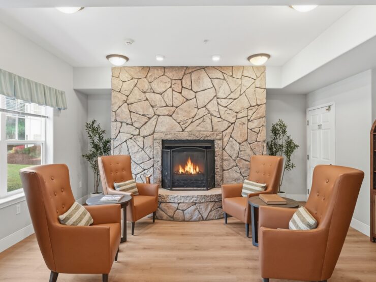 A welcoming lounge with plush seating around a warm fireplace, inviting community and connection.