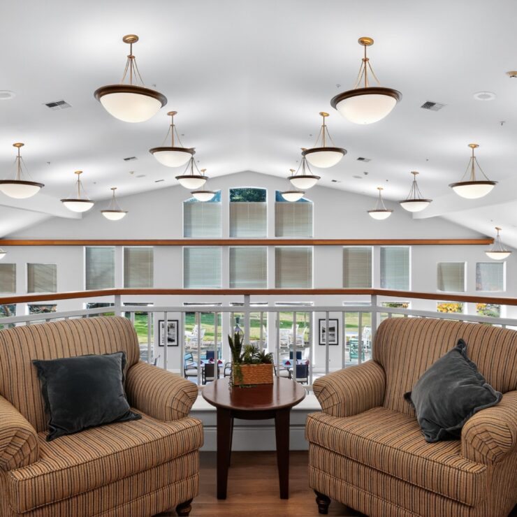 Inviting seating area overlooking a bright, spacious community space, perfect for socializing and relaxation.