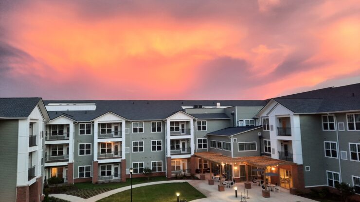 A serene sunset bathes the welcoming courtyard, inviting community and connection among residents.