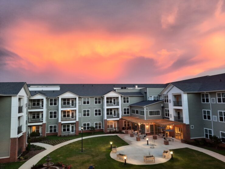 A serene sunset bathes the welcoming courtyard, inviting community and connection among residents.